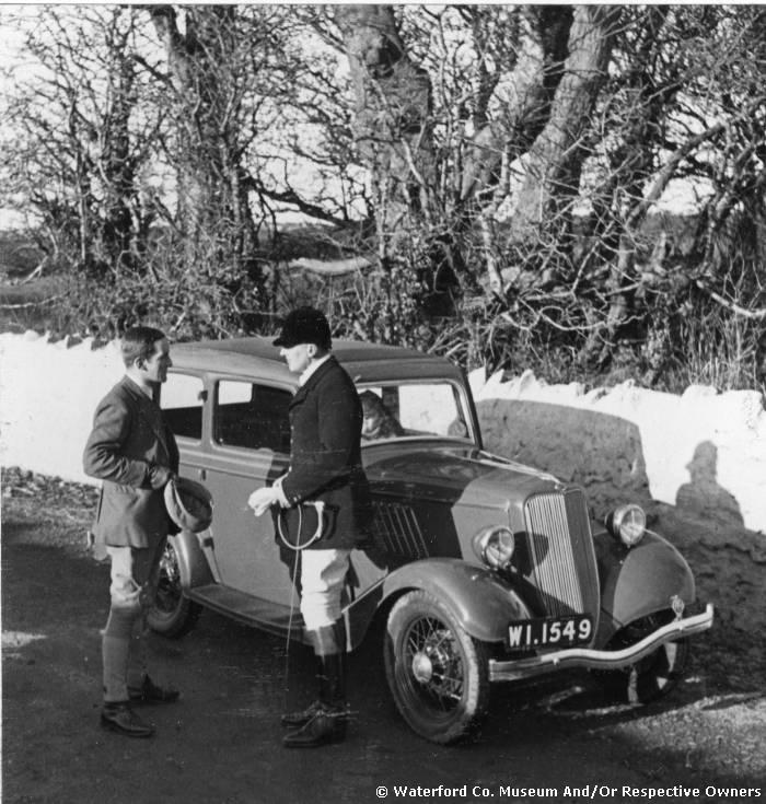 Two Huntsmen By A Car On A Country Road.