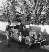Two Huntsmen By A Car On A Country Road.